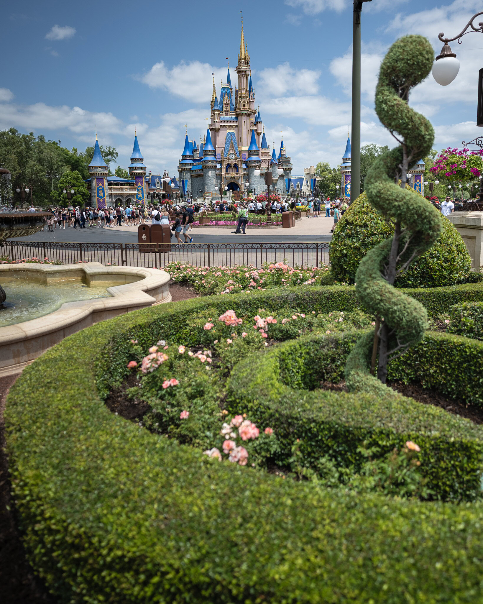 Cinderella Castle at Magic Kingdom Cinderella Castle at Magic Kingdom with gardens and topiary in the foreground on a sunny day.