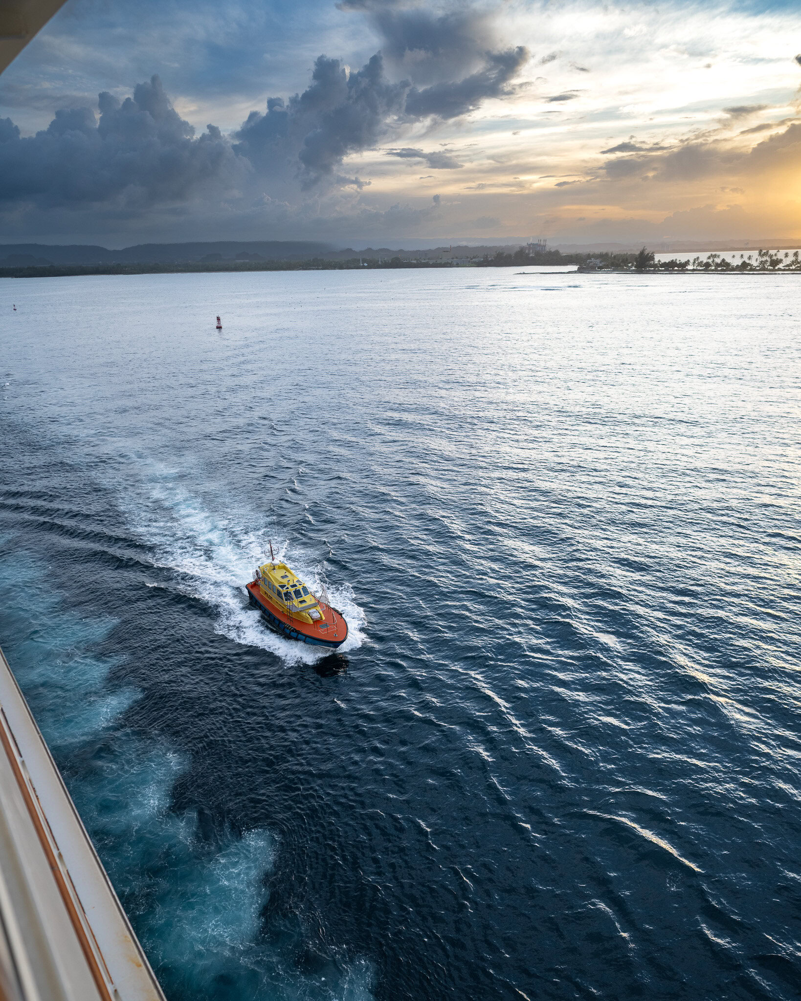 Pilot boat alongside Disney Magic during sail-away from San Juan Puerto Rico with ocean waves in view.