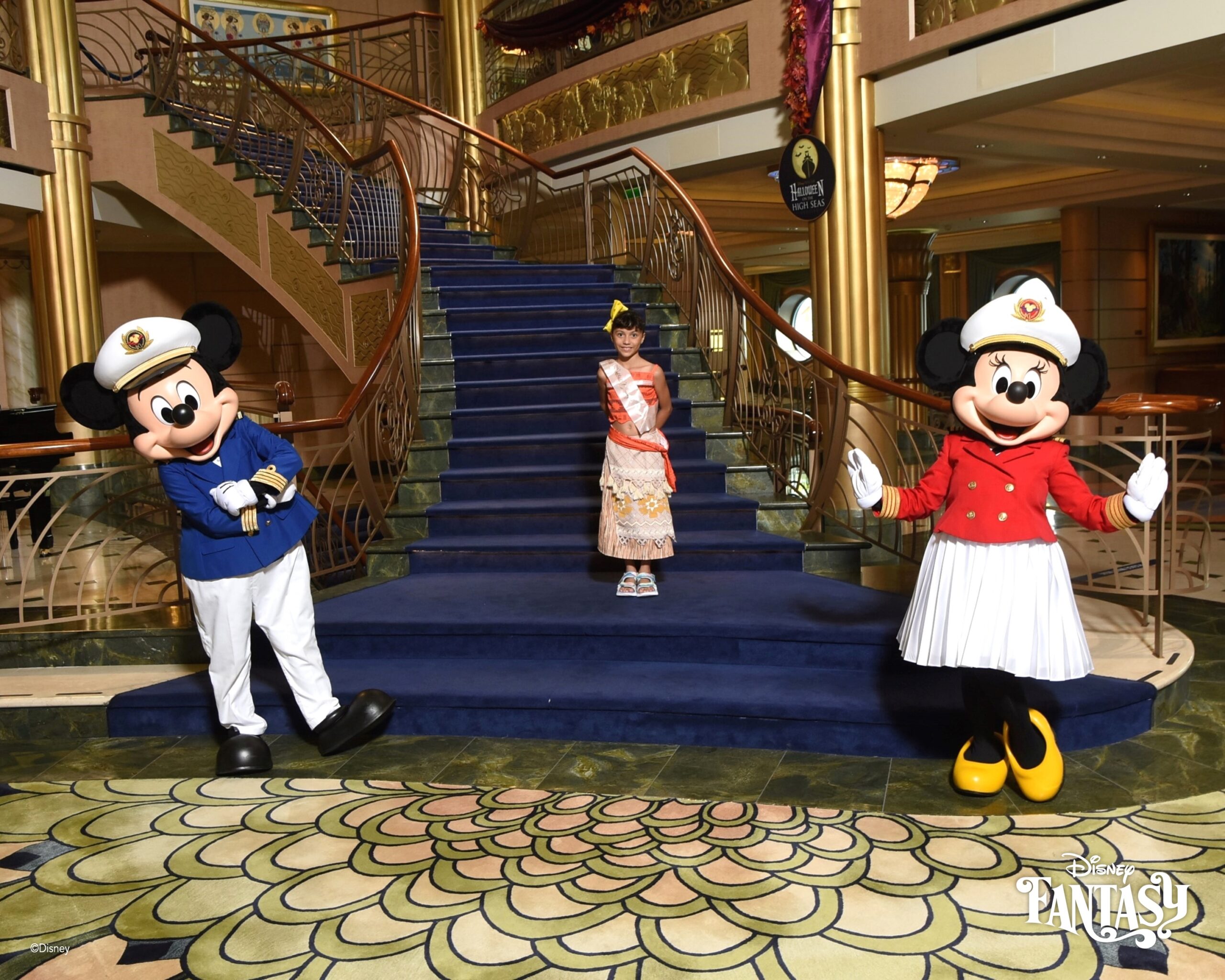 Daniela posing with Captain Mickey and Captain Minnie on Disney Fantasy cruise staircase