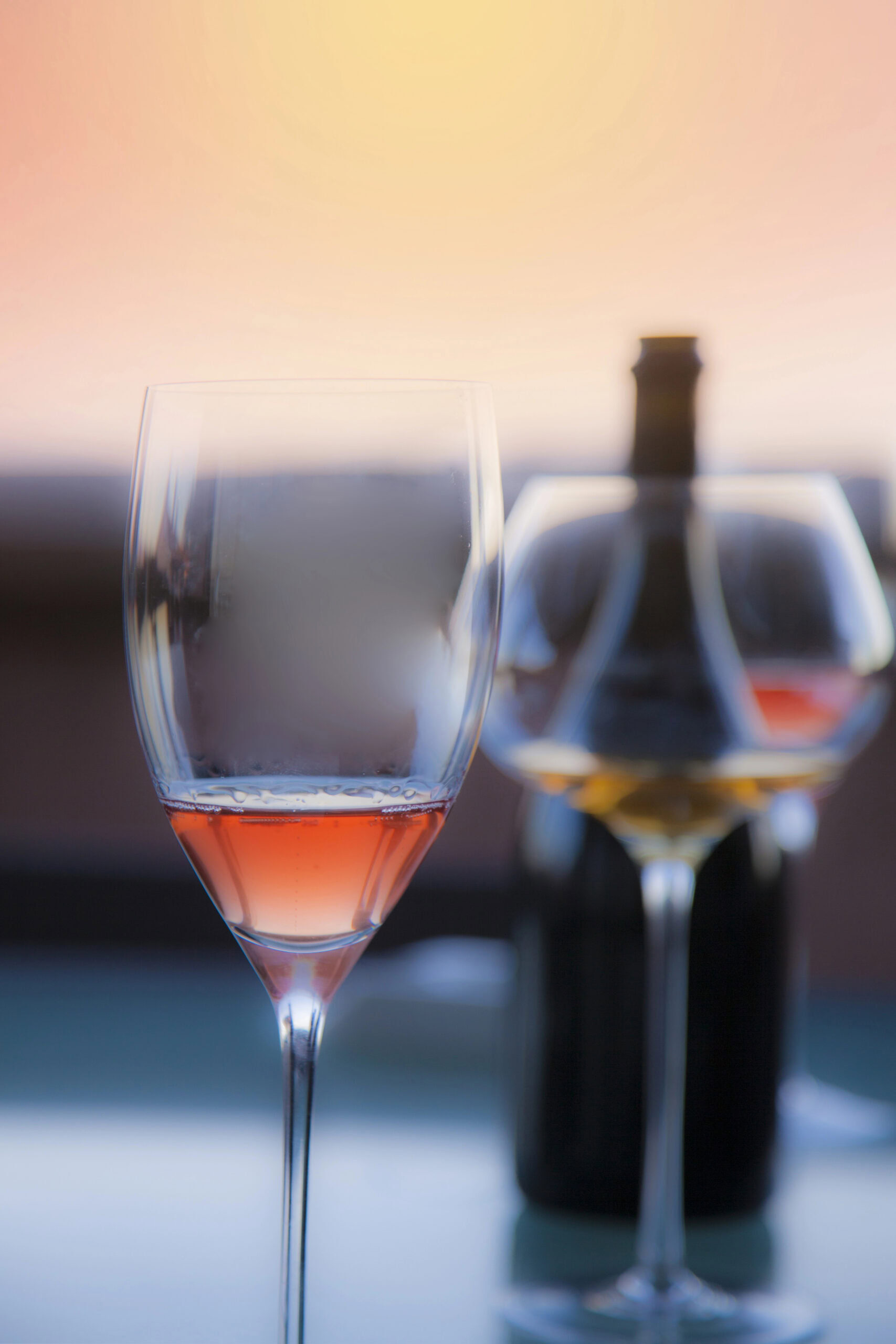 Ros&eacute; and white wine glasses beside a bottle at sunset for a private wine experience in Puerto Rico