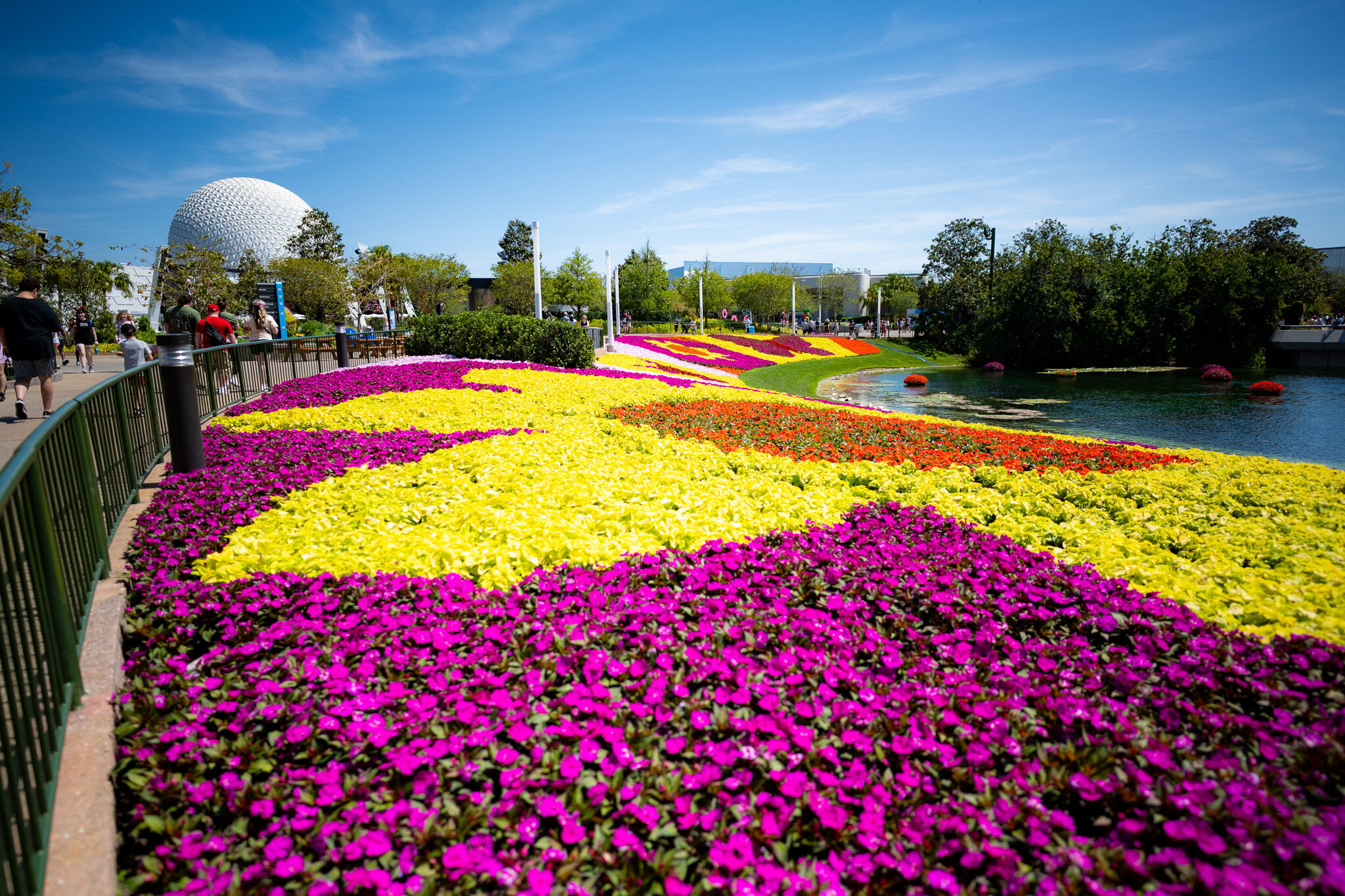 Colorful flower beds at EPCOT Flower & Garden Festival with Spaceship Earth in the background
