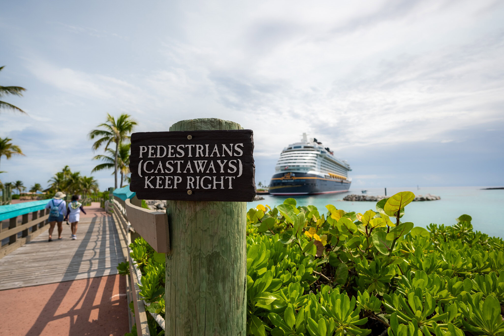 Disney Fantasy docked at Castaway Cay as guests walk back to the ship