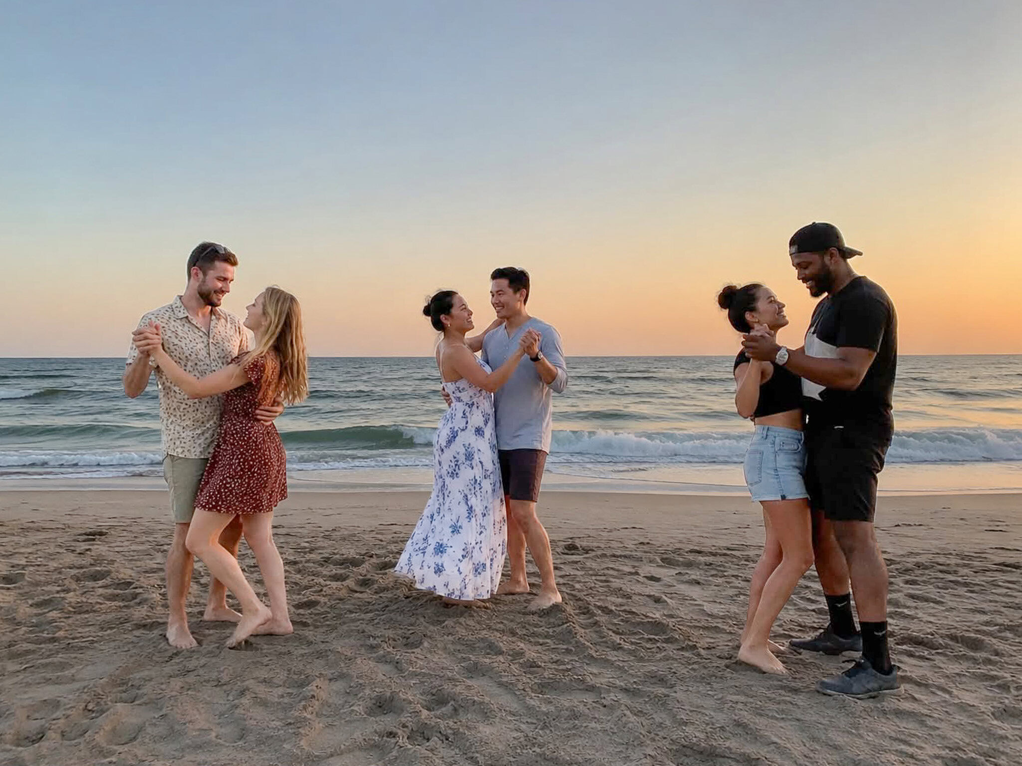 Couples learning Salsa and Bachata during a sunset beach dance experience at Ocean Park Beach in San Juan, Puerto Rico.