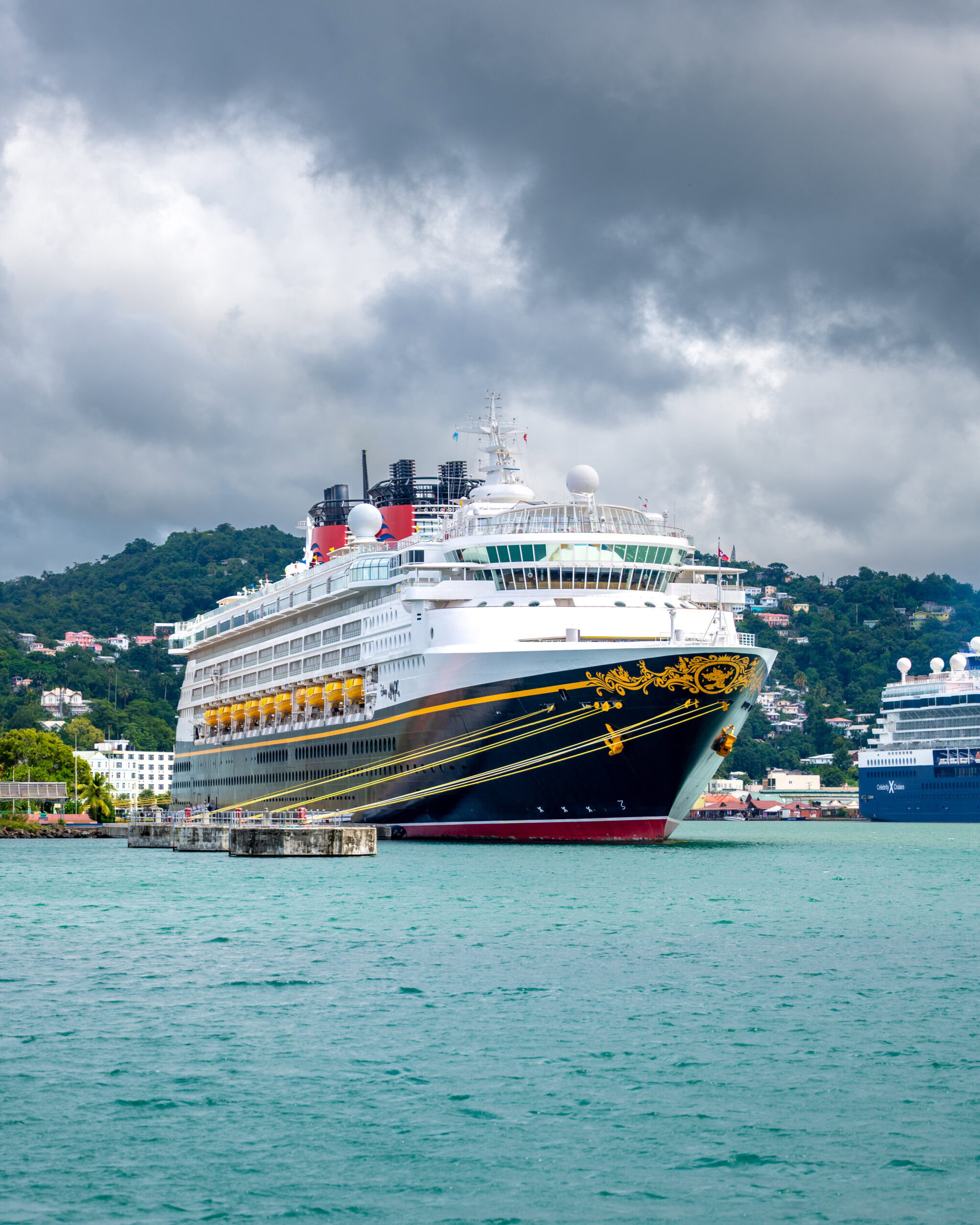 Disney Magic cruise ship docked in Castries, St. Lucia with mountains in the background.