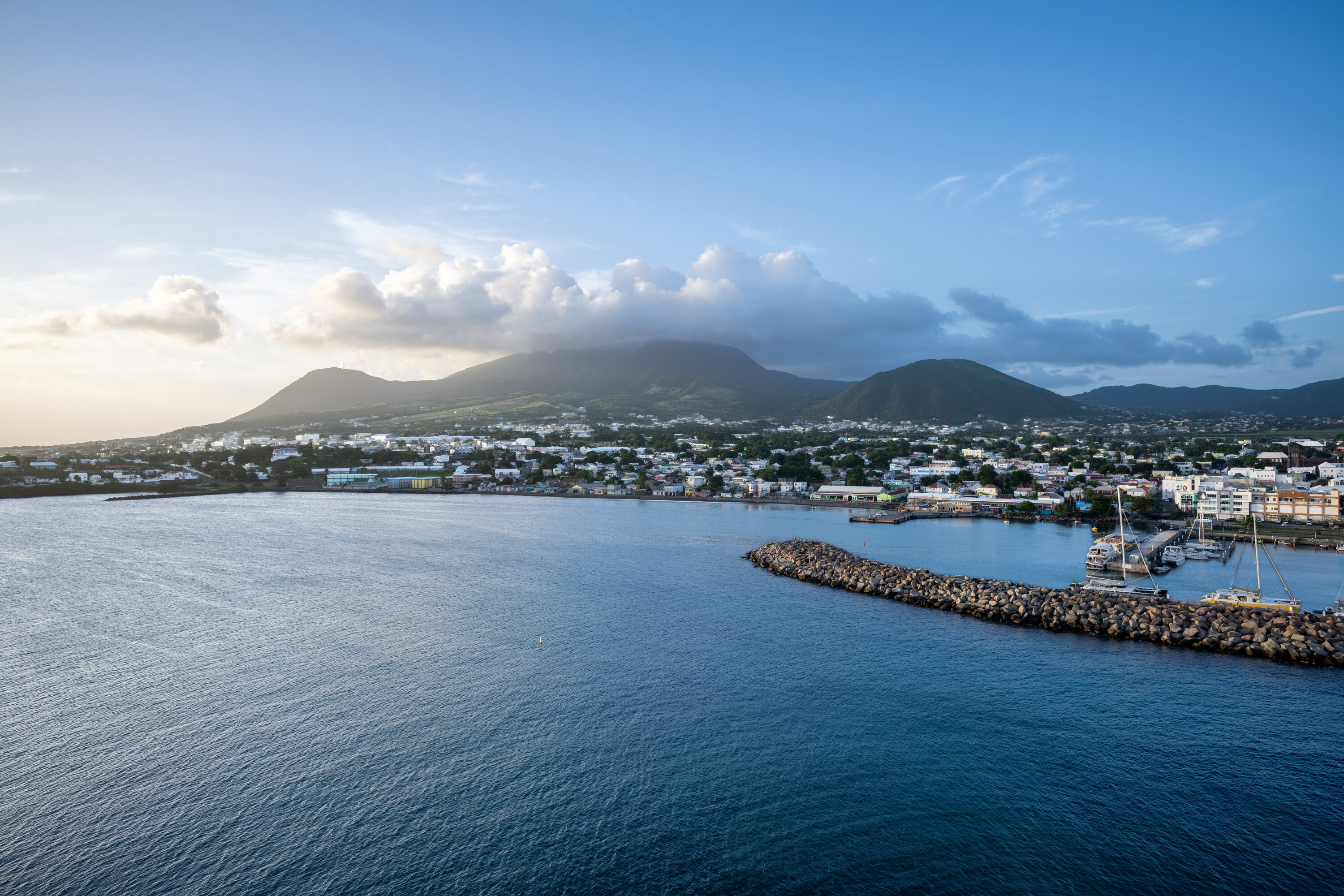 St. Kitts port and marina with mountains in the background, seen from a cruise ship deck.