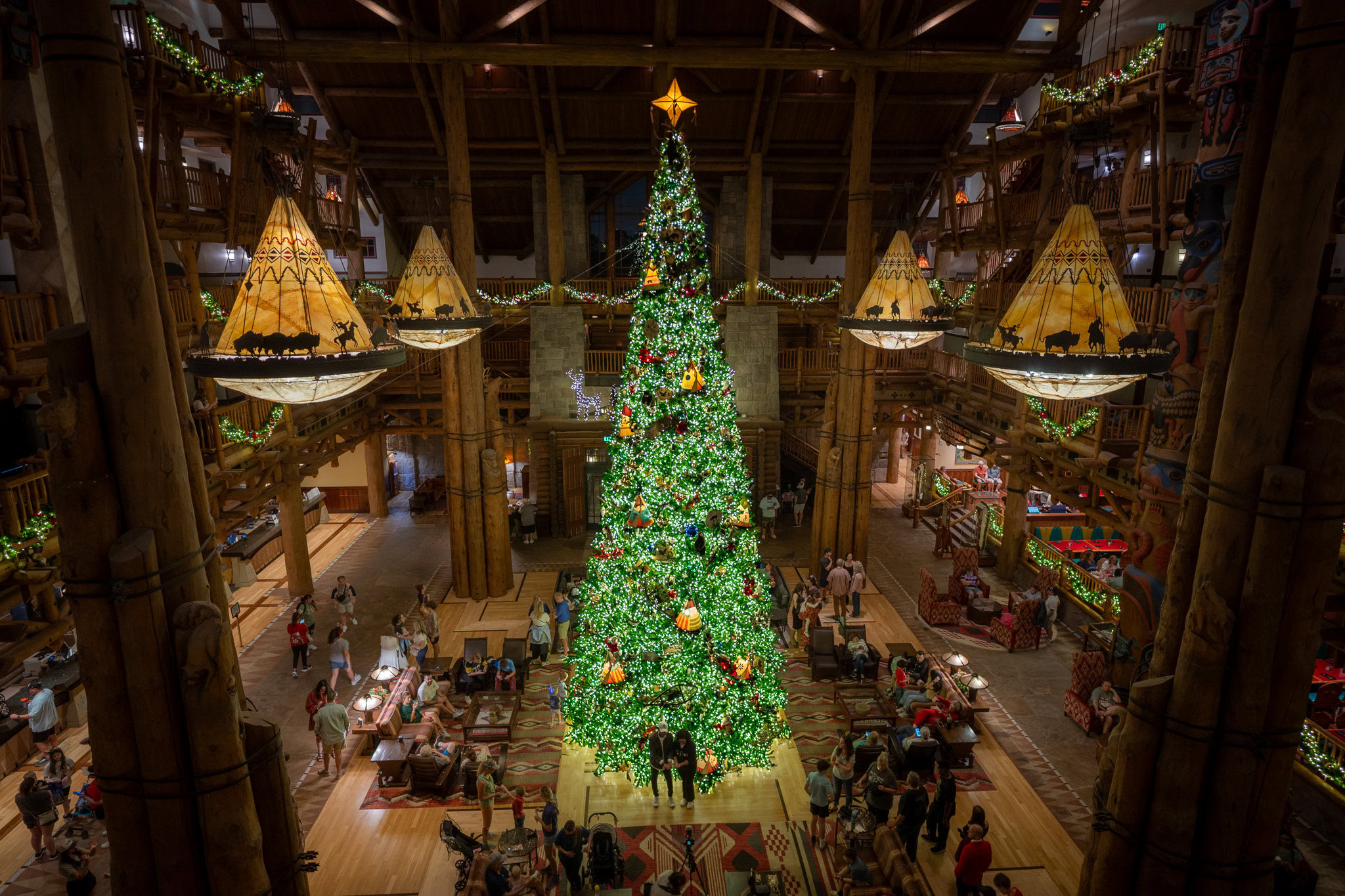 Disney’s Wilderness Lodge grand lobby with towering Christmas tree and holiday decor viewed from above
