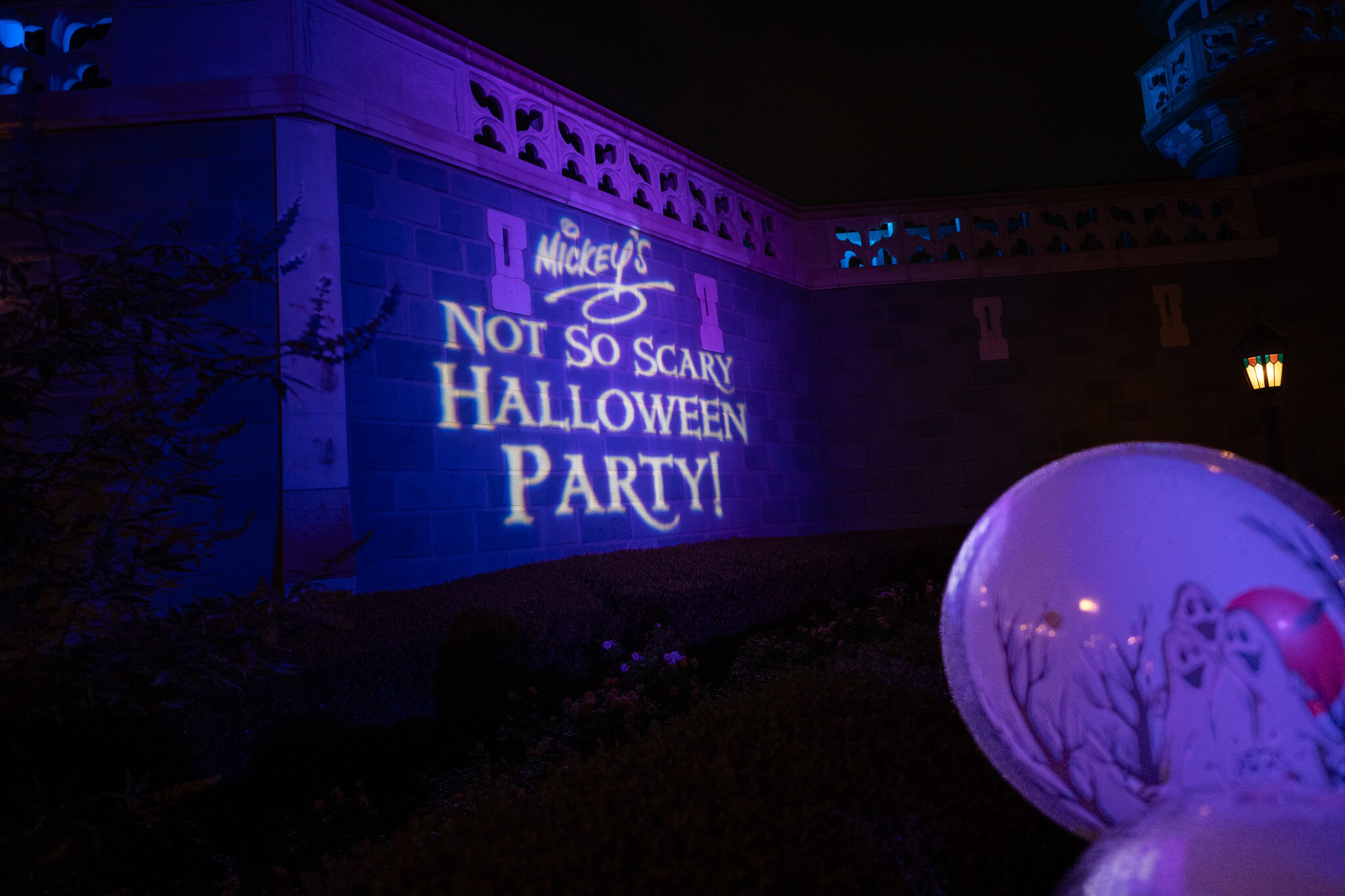 Mickey’s Not-So-Scary Halloween Party logo projection at night with balloon in foreground