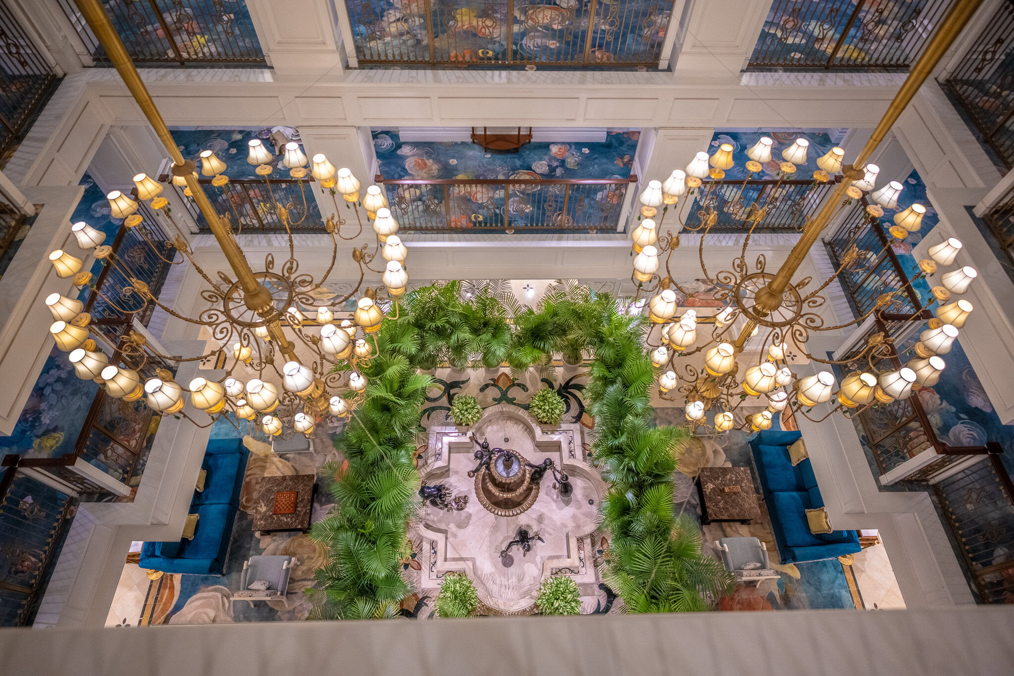 Lobby of Disney’s Grand Floridian Resort & Spa Disney Vacation Club Villas with chandeliers and central fountain at Walt Disney World.