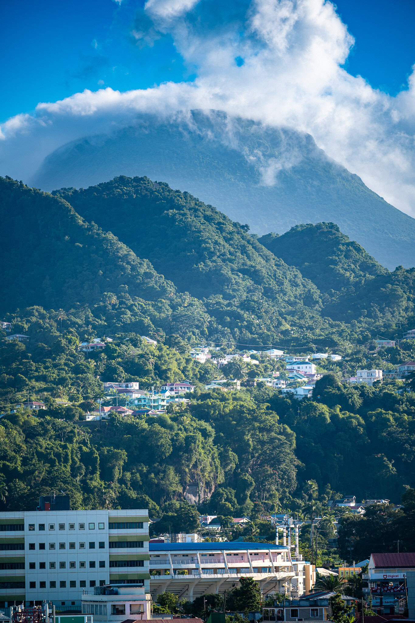 Lush mountains and clouds above Dominica rainforest near the cruise port