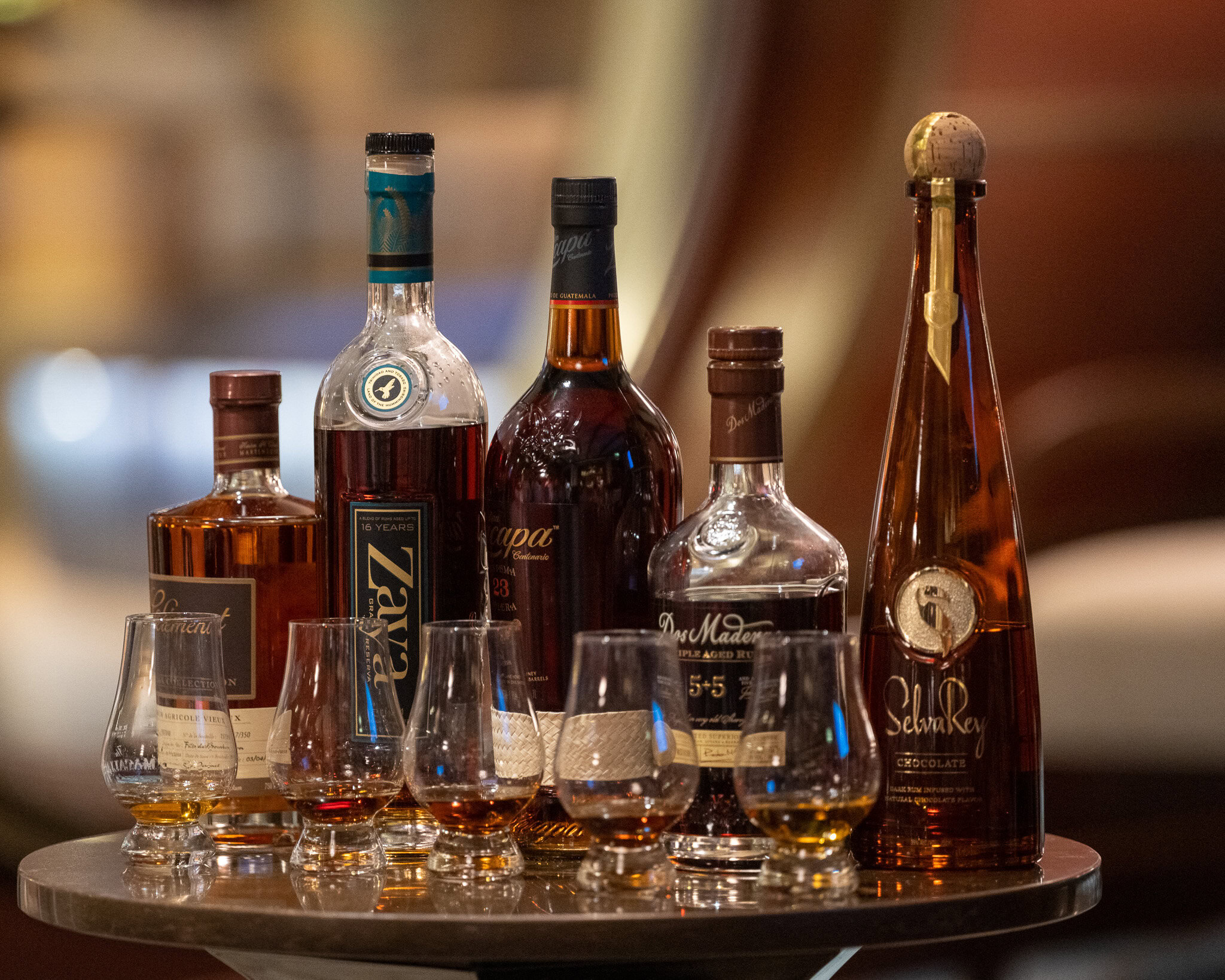 Assorted rum bottles and tasting glasses arranged for a Disney Cruise Line rum tasting experience.