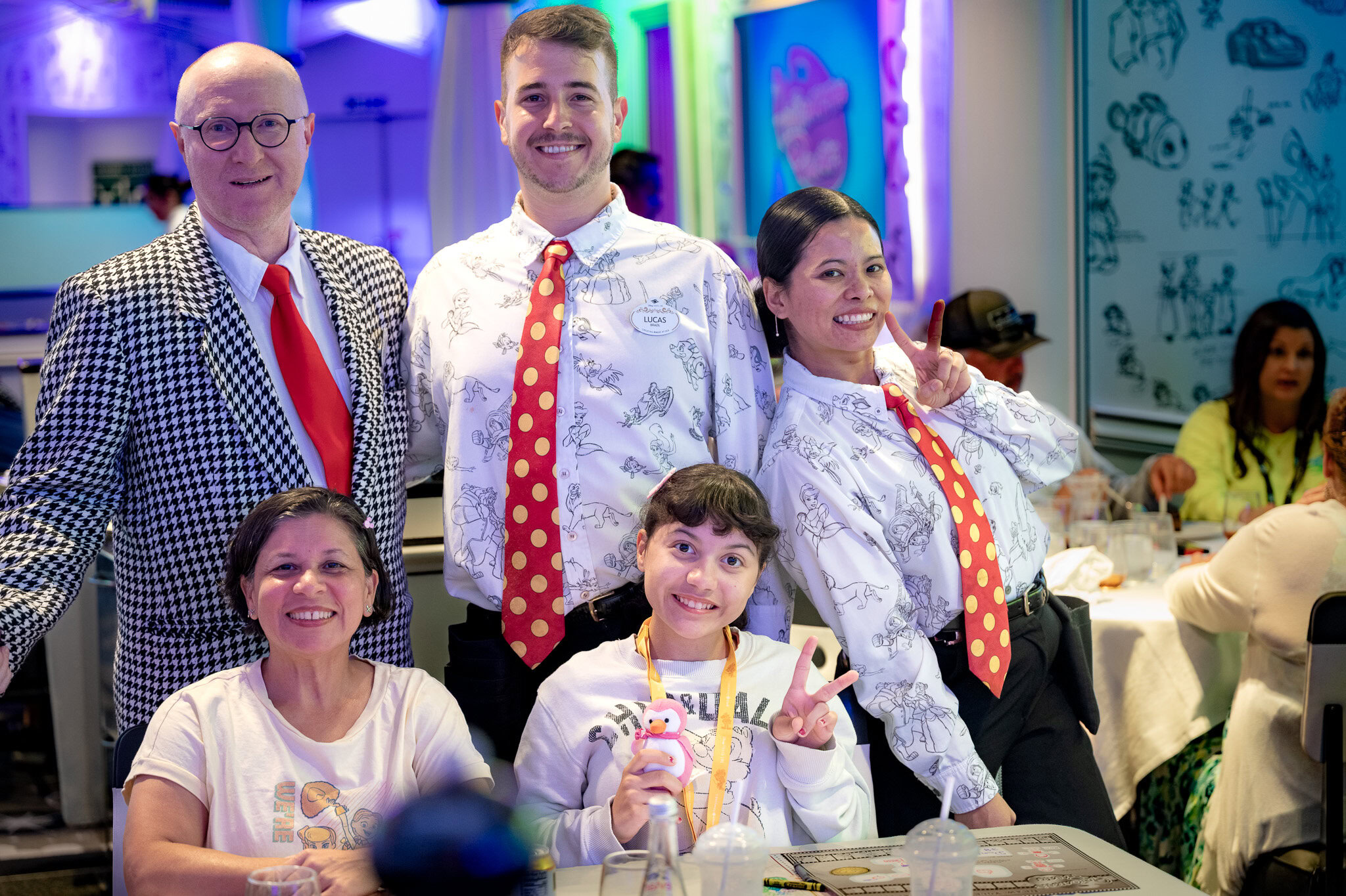 Daniela and Lucy pose with Mr. Z, Lucas, and Miau from their Disney Cruise Line dining team aboard the Disney Magic.
