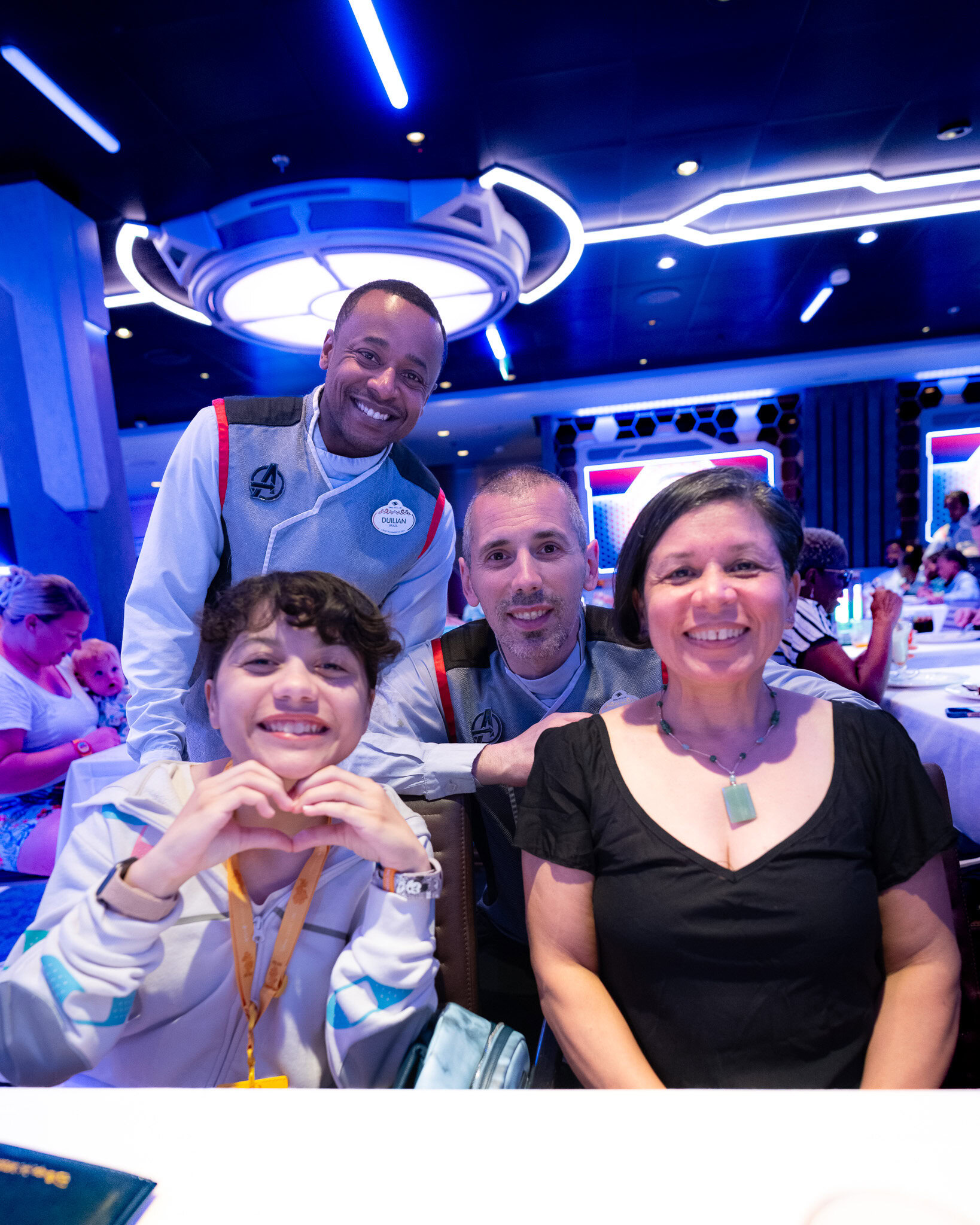 Daniela and Lucy with Disney Wish dining team members Vojin and Dulian at World of Marvel.