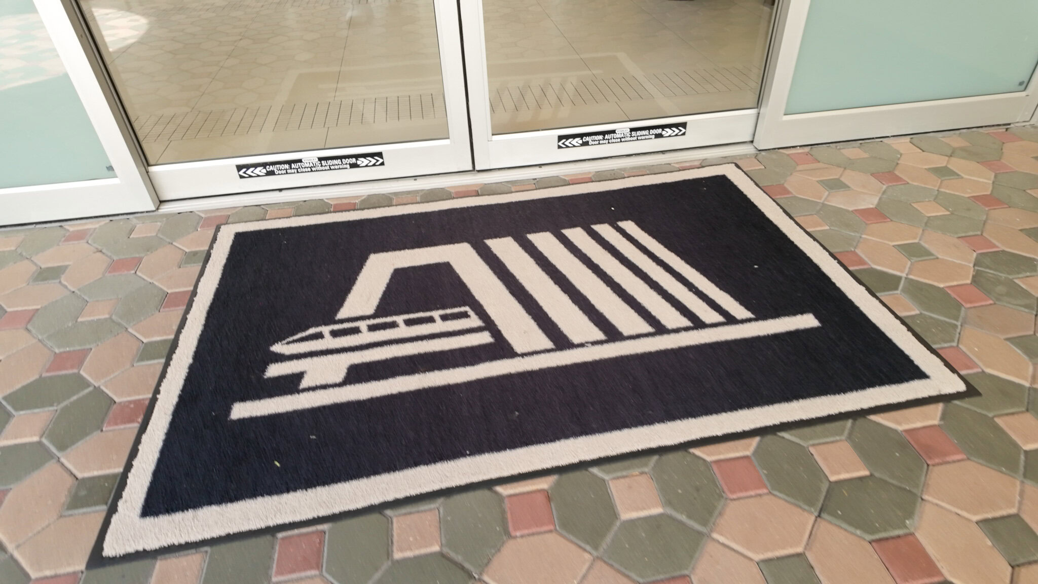 Disney’s Contemporary Resort entrance mat outside automatic glass doors.