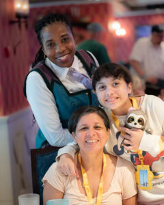 Disney Wish Arendelle Frozen Dinner server Lisa posing with smiling family guests.