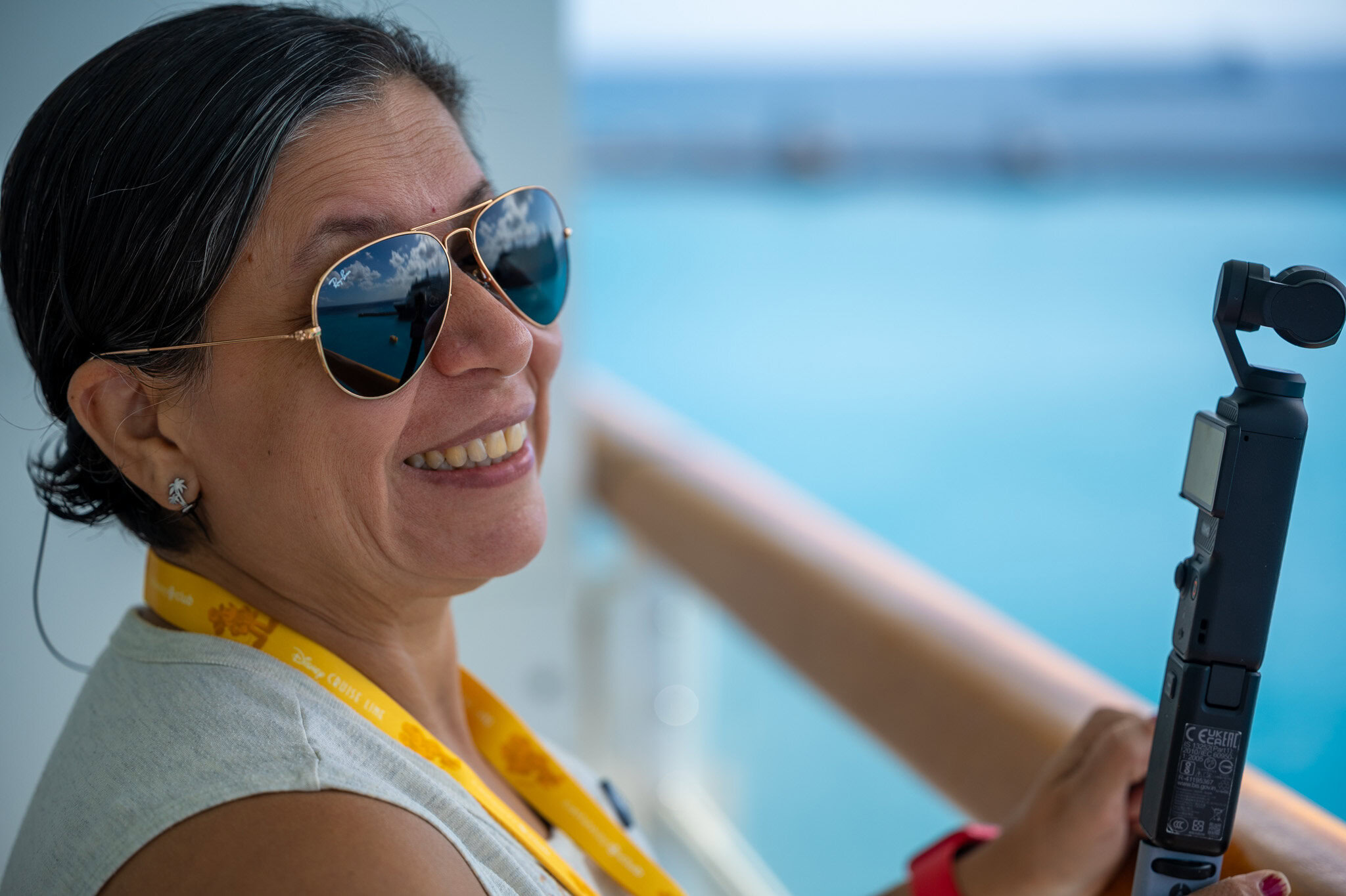 Lucy from Laugh and Gear recording video from a cruise ship balcony overlooking the Caribbean Sea.