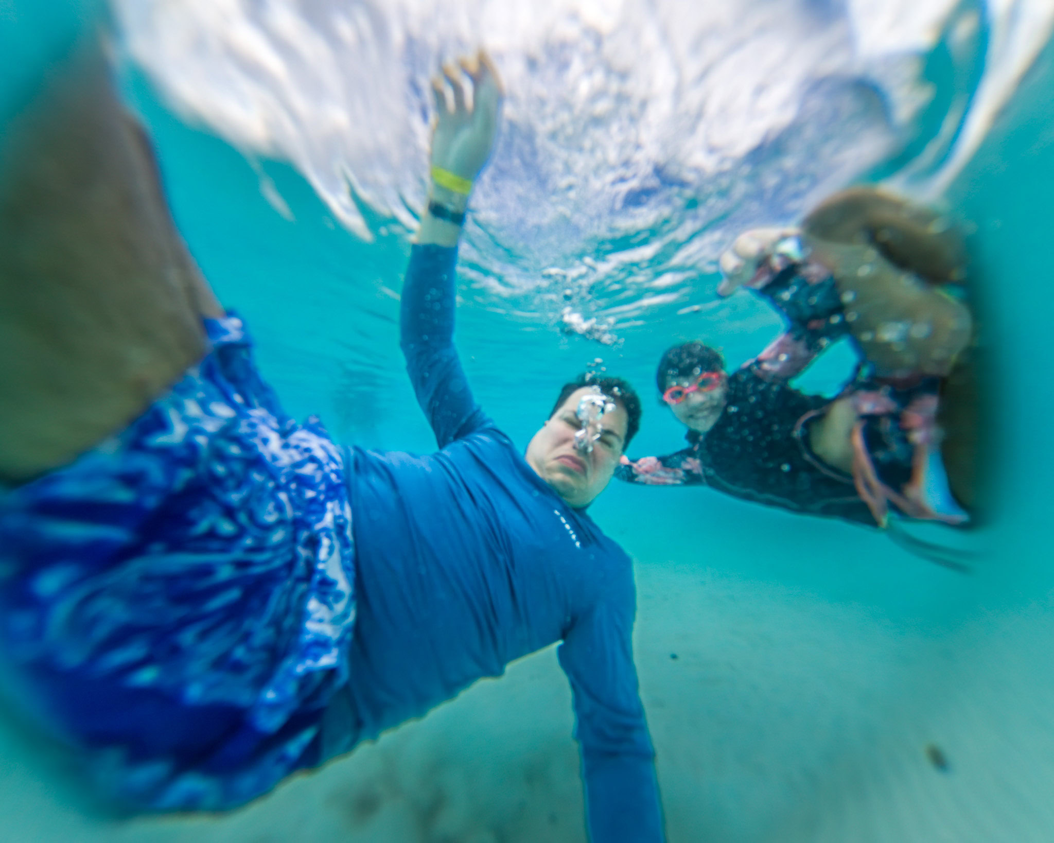Daniela and Raúl swimming underwater at Harbour Lights Beach in Barbados.