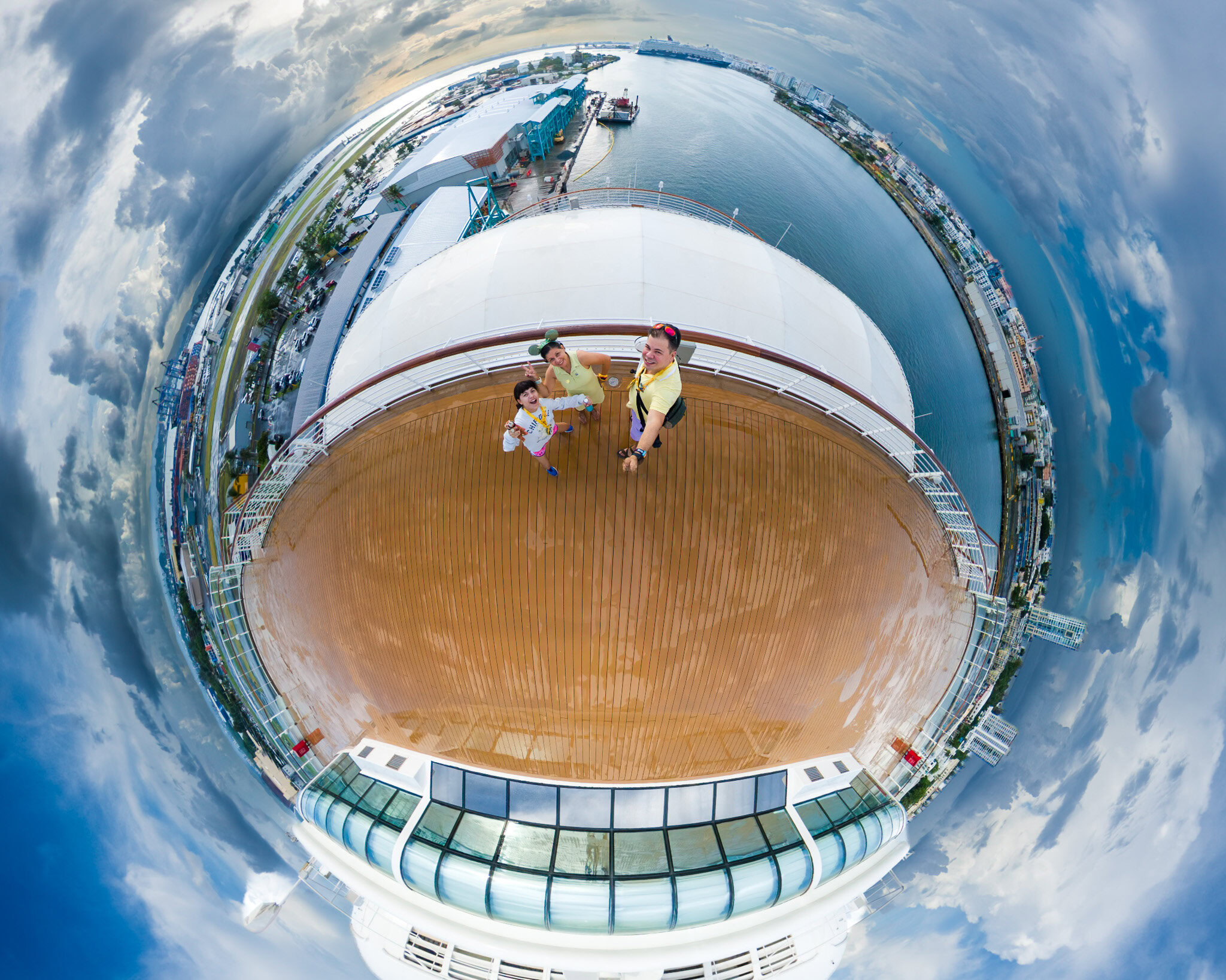 Raúl, Lucy, and Daniela from Laugh and Gear on the upper deck of a Disney cruise ship, captured with an Insta360 X5 camera.