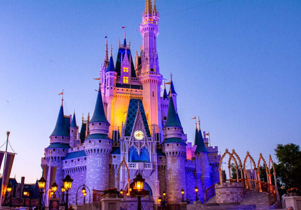 A vibrant twilight view of Cinderella Castle glowing in purples and golds, a magical moment captured at Magic Kingdom in Walt Disney World.