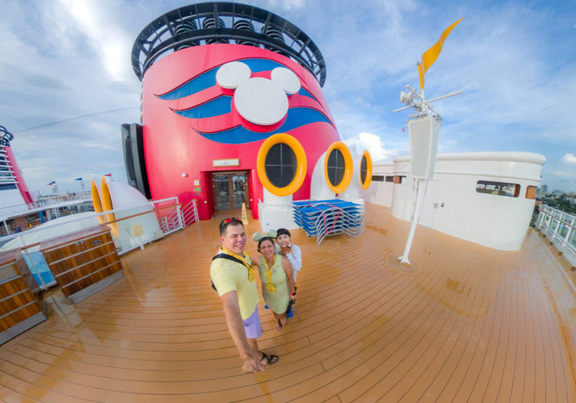 Raúl, Lucy, and Daniela on the Disney Magic deck during embarkation day for their Disney Cruise from San Juan Puerto Rico.