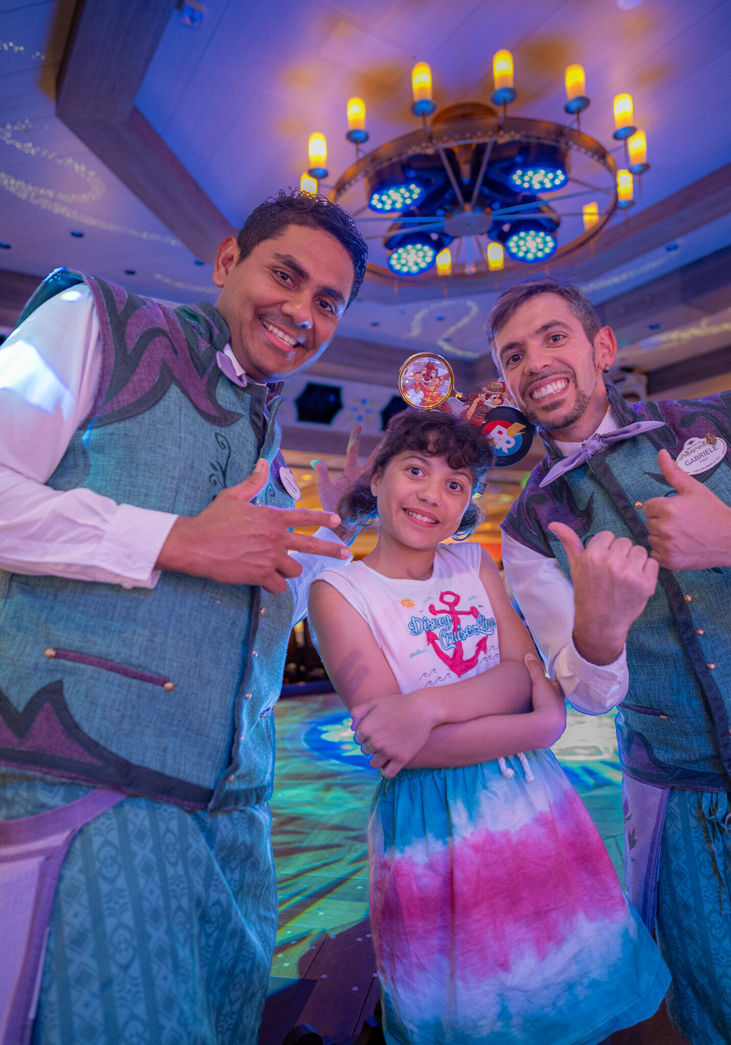 Merlin and Gabriele from the Disney Cruise Line dining team pose with Lucy at Arendelle restaurant.